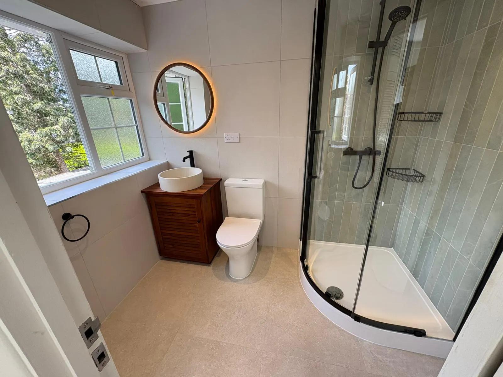 Completed Pureflo bathroom with glass shower, timber vanity and round mirror